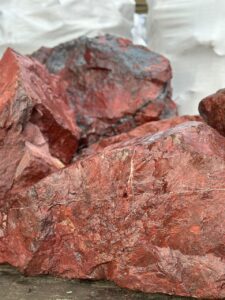 Крупный красный валун из диабаза для декоративного оформления участка