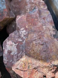 Крупный красный валун из диабаза для декоративного оформления участка